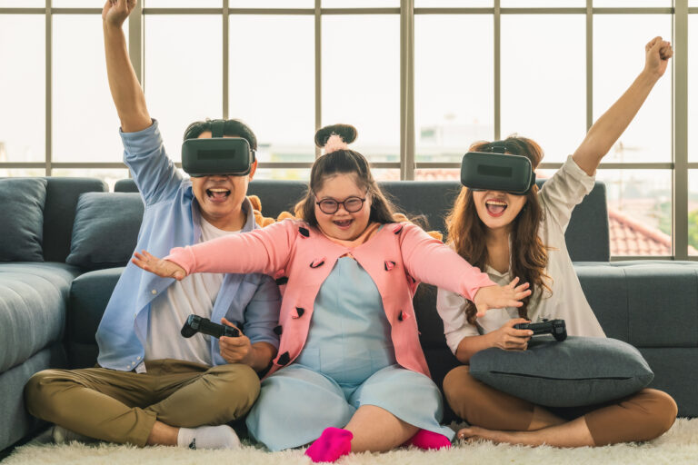 Virtual reality for autism: Family of three sitting on the floor while playing virtual reality games in a living room.